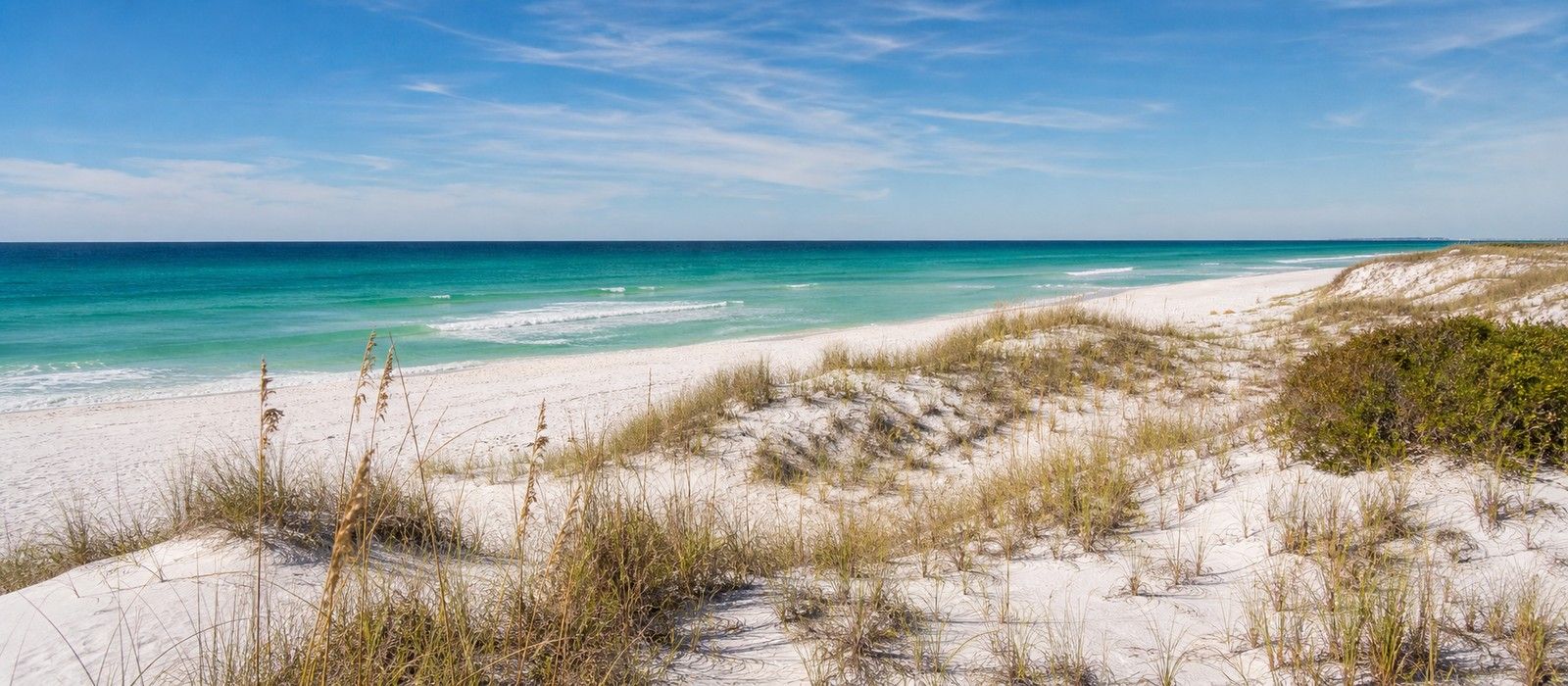 Empty white sand dunes and emerald water at Henderson Beach State Park in Destin in October