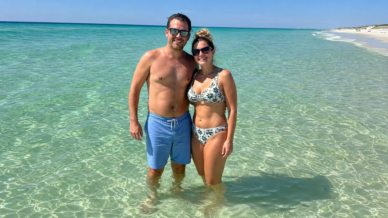 Couple wading in the emerald-green Gulf waters off Destin Florida's famous white-sand beach on a clear summer afternoon