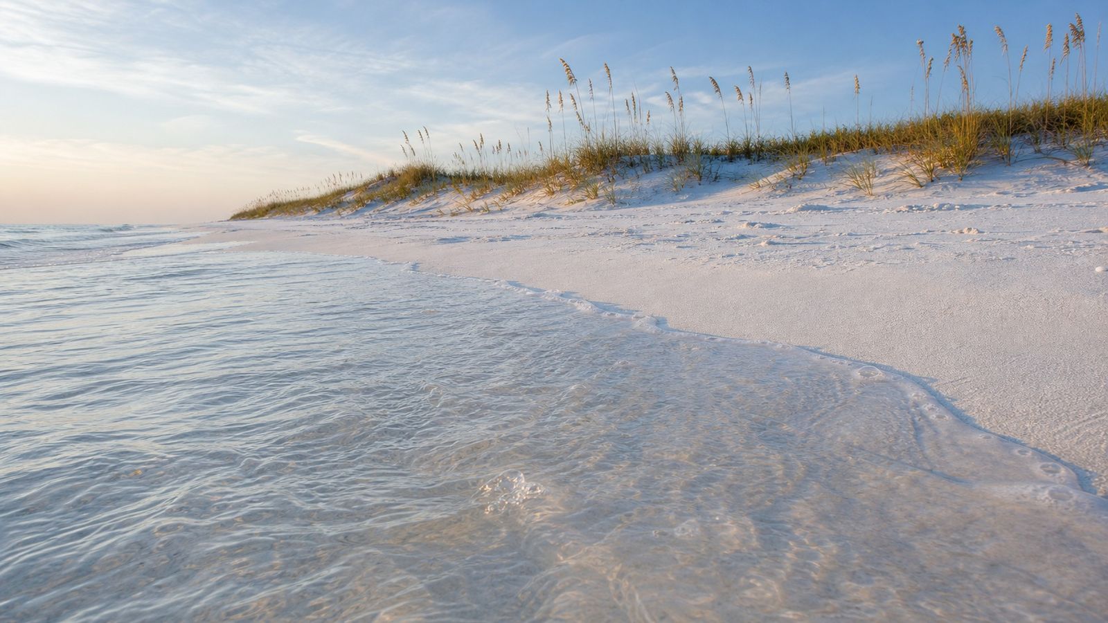 Crystal-clear emerald Gulf water washing over white quartz sand at Henderson Beach State Park in Destin Florida in early morning