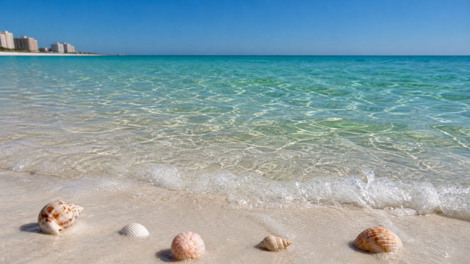Crystal clear emerald-green Gulf of Mexico water over brilliant white quartz sand showing underwater visibility at a Florida beach