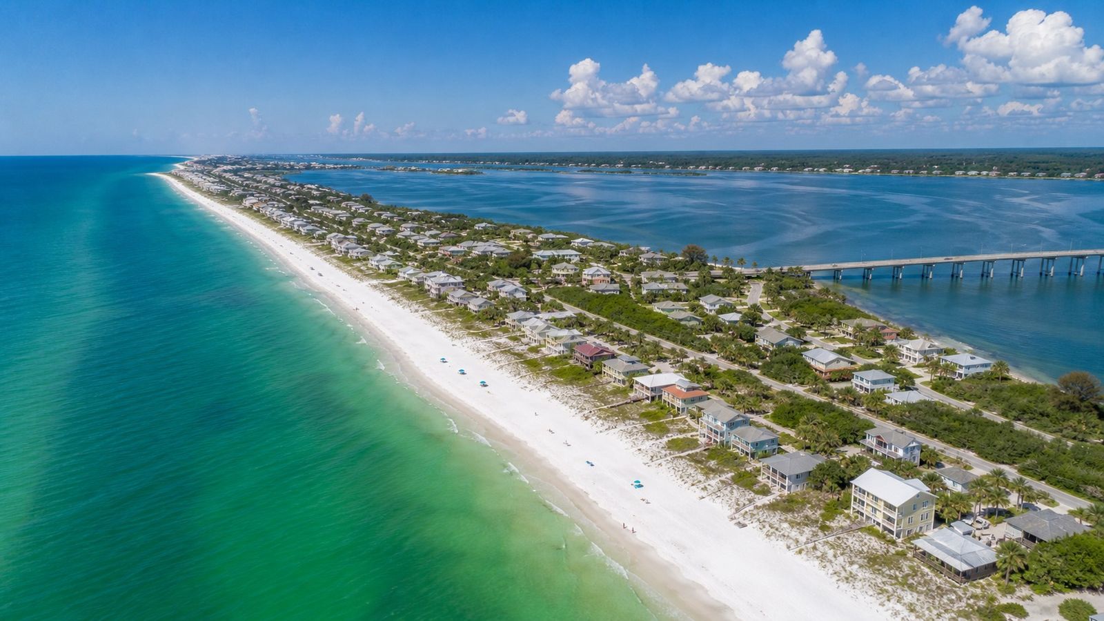Aerial view of a Florida Gulf Coast barrier island with white sand beaches and emerald water on both sides