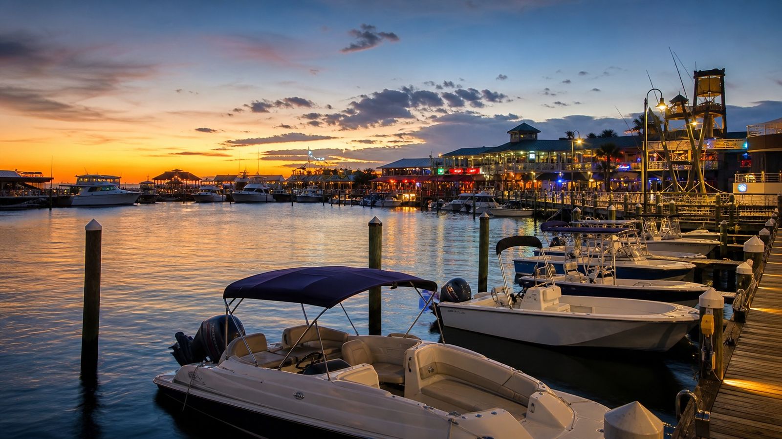 Destin Harbor with boats docked at HarborWalk Village at sunset