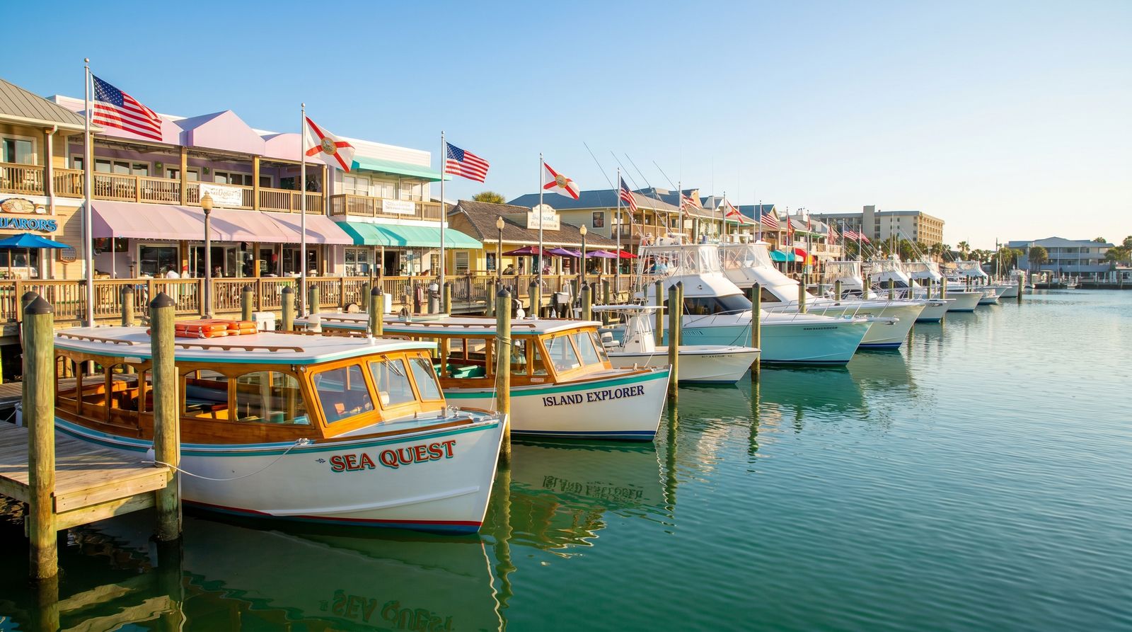 Charter tour boats and catamarans lined up at HarborWalk Village in Destin Florida on a warm afternoon