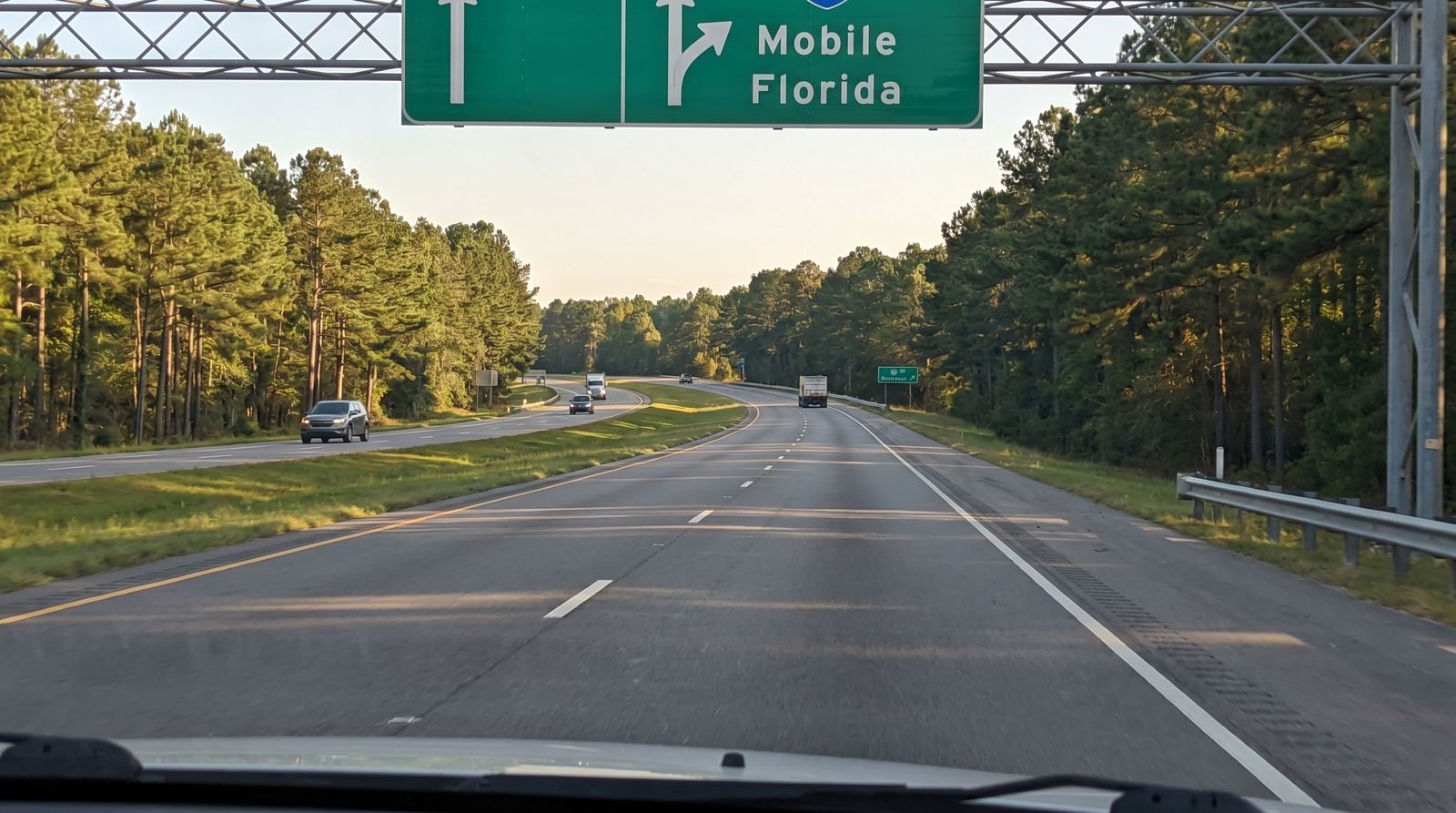 I-65 interstate highway southbound through Alabama pine forests heading toward the Florida Panhandle on a clear summer day