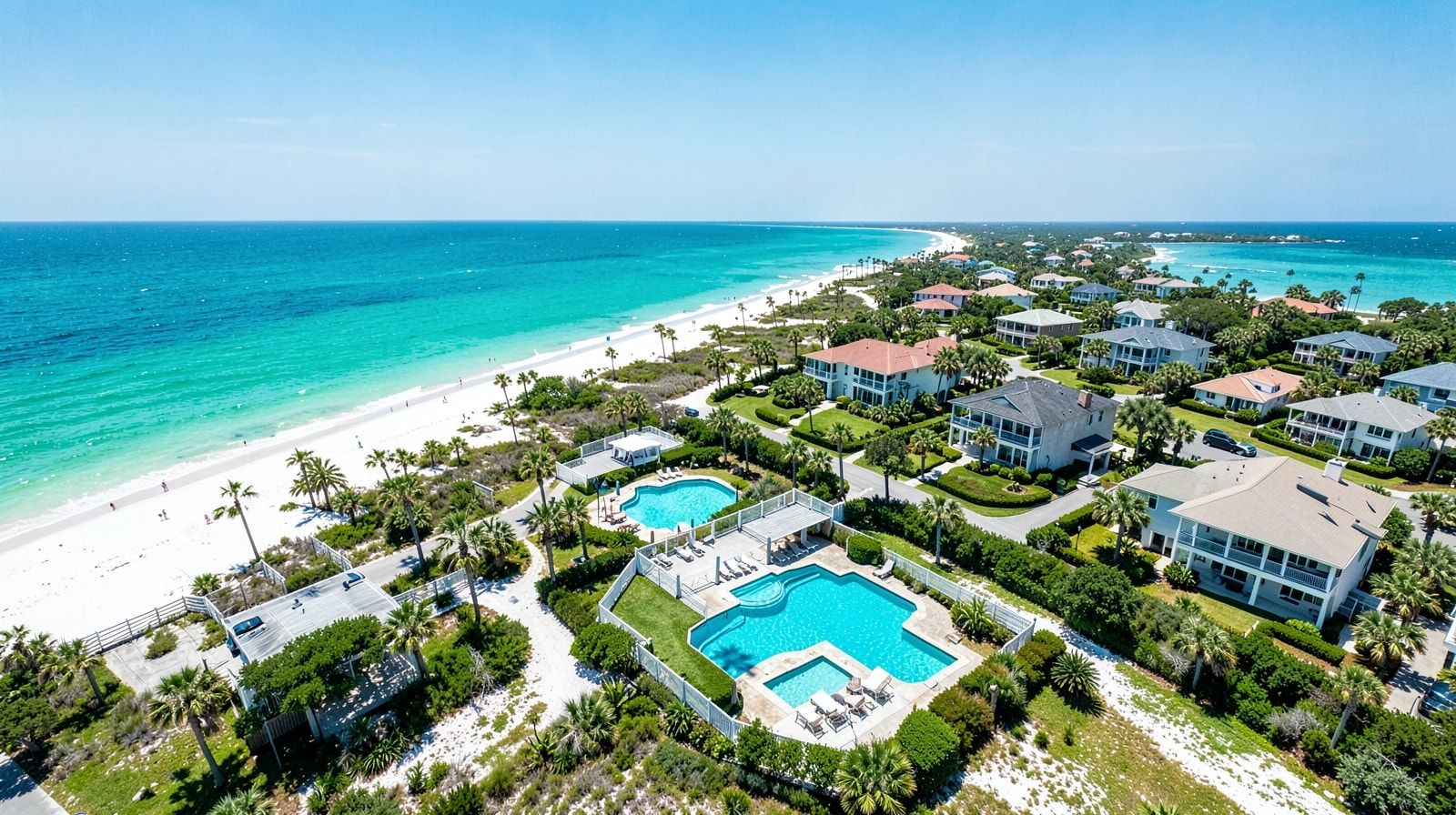 Aerial view of Gulf Coast vacation rental neighborhood with private pools and turquoise Gulf in the distance