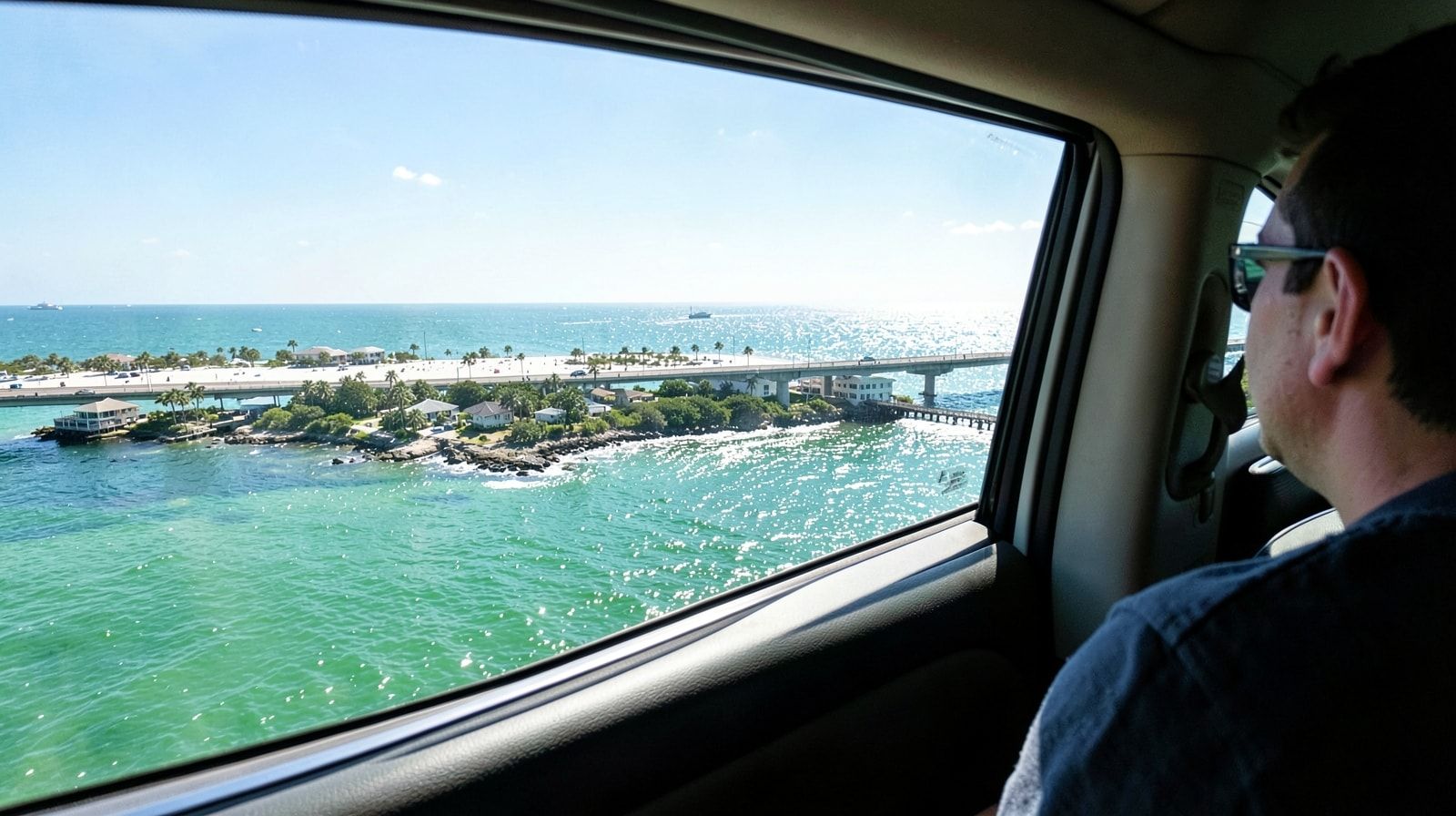 View from a car window crossing a bridge into Destin Florida with the emerald Gulf of Mexico sparkling below